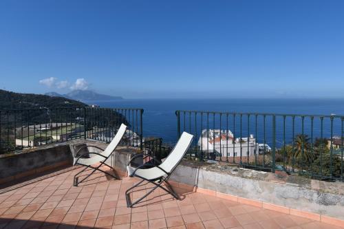 two chairs sitting on a balcony overlooking the ocean at La Ciucciara Holiday Homes in Massa Lubrense