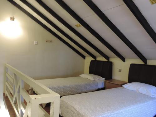 a room with two beds in a attic at Cameronian Inn in Cameron Highlands