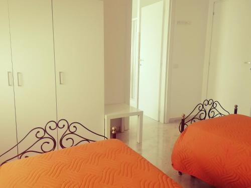 una camera con letto arancione e armadi bianchi di A Casa Mia a Matera