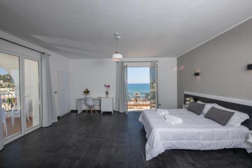 una camera con letto e vista sull'oceano di Hotel Baia D'oro a Licata