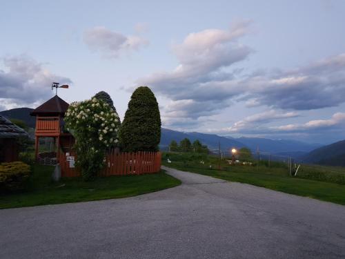 a fence with two trees next to a road at Residence Condor Apt Schlern in Maranza