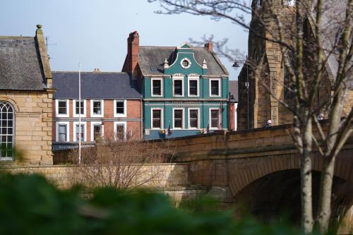 una casa en la parte superior de un puente al lado de un edificio en The Auction House, en Morpeth