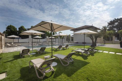 a group of chairs and umbrellas on the grass at VILLA BERNASCONI in Narzole