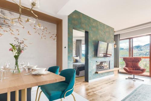 a dining room with a table and chairs and a fireplace at Tatra Resort & SPA in Kościelisko