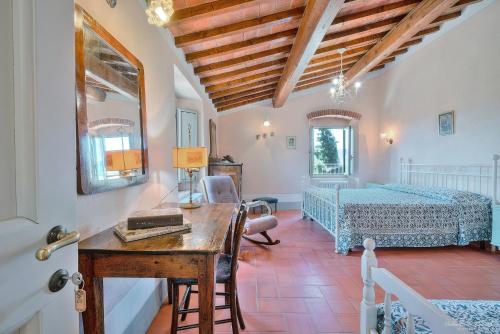 1 dormitorio con escritorio, 1 cama y 1 mesa en Agriturismo Corzano, en Barberino di Mugello
