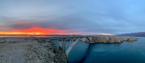 a bridge over a body of water with a sunset at Apartment Anamaria in Pag