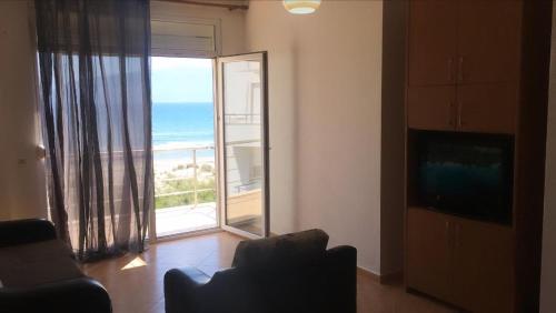 een woonkamer met een groot raam met uitzicht op de oceaan bij Relax Rental in Vlorë