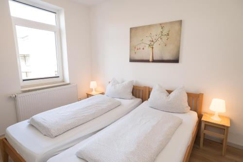 2 camas en una habitación con una foto en la pared en FeWo Engler Wallstraße W4, en Lüneburg