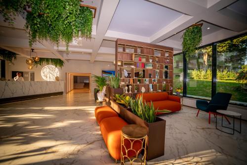 an office lobby with orange furniture and plants at Hotel Corina in Venus