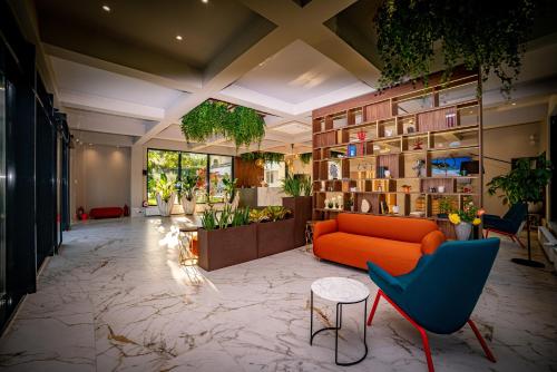 a lobby with an orange couch and some plants at Hotel Corina in Venus
