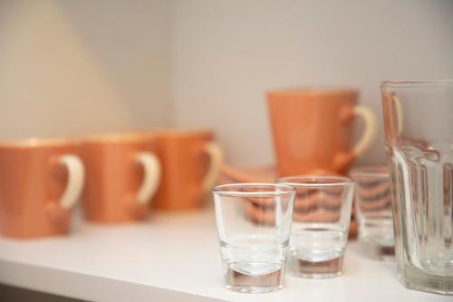three glasses sitting on a counter with orange cups at 4 Studios Becic in Budva