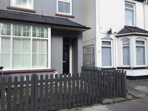 a white house with a fence in front of it at A Wave From It All in Great Clacton