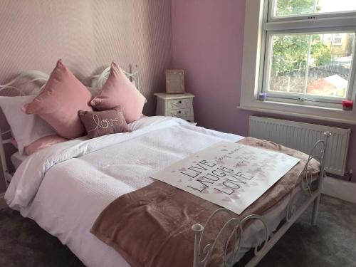 a bedroom with a bed with a sign on it at A Wave From It All in Great Clacton