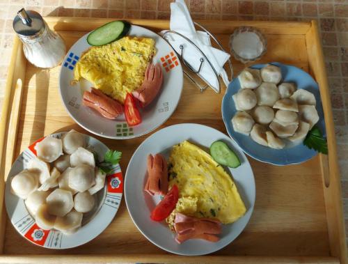 a wooden table topped with plates of breakfast food at Отель Маленький Рай in Zatoka