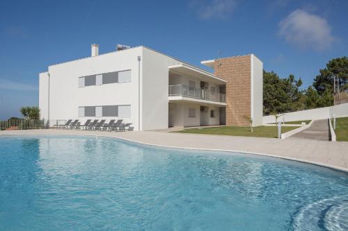 a house with a swimming pool in front of a building at Muralha 2 - Holiday Apartments - By SCH in Nazaré