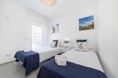 two beds in a room with white walls at Casas do Parque - By SCH in São Martinho do Porto