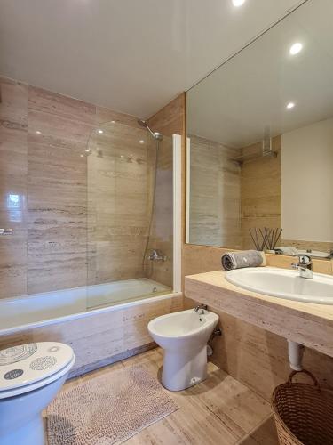 y baño con bañera, aseo y lavamanos. en Fantastic 3 bedroom apartment, 300m to the sea, en Lloret de Mar