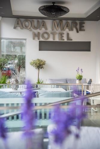 a restaurant with a glass table and a sign that reads awura mate hotel at Aqua Mare Hotel in Nea Kalikratia