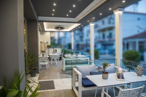 un patio con mesas y sillas en el balcón en Aqua Mare Hotel, en Nea Kalikratia