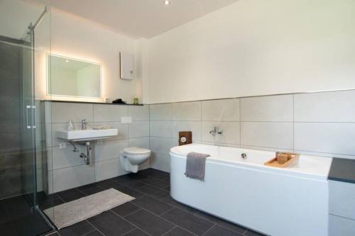 ein Badezimmer mit einer Badewanne, einem Waschbecken und einem WC in der Unterkunft Ferienwohnung Träwa in Sulzbach