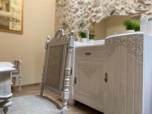 een badkamer met een wastafel, een spiegel en een stoel bij Casa Maistra Residence in Rethimnon