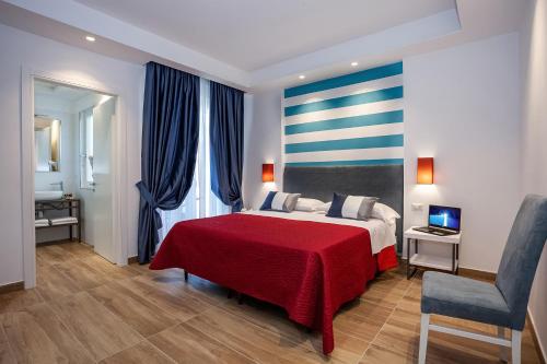 a bedroom with a red bed with a red blanket at Hotel Angelina in Sant'Agnello