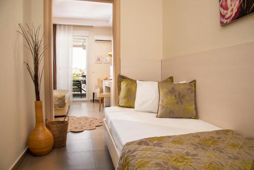 a bedroom with a bed and a vase on the floor at Aqua Mare Hotel in Nea Kalikratia