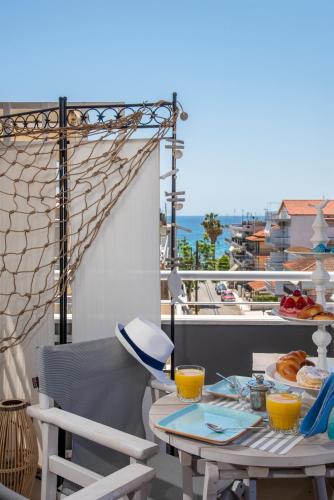 a table and chairs on a balcony with a view of the ocean at Aqua Mare Hotel in Nea Kalikratia