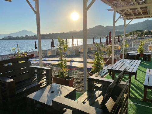 a picnic table and benches under a pavilion next to the water at Sansi´s Sapri Camere in Sapri