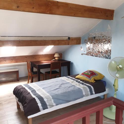 - une chambre avec un lit et une table avec un bureau dans l'établissement villa Natacha, à Villeparisis