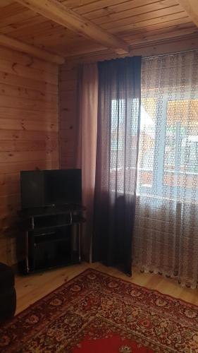 a living room with a television and a window at Садиба For Rest in Svityazʼ