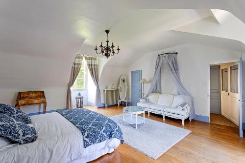 a bedroom with a bed and a couch in it at Manoir de la Mazeraie, idéal pour le télétravail in Joué-lès-Tours