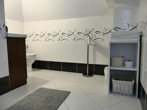 uma casa de banho com WC e parede em preto e branco em Apartament Jutrzenka em Spytkowice