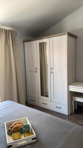 a white cabinet with a tray of food on a bed at Apartmani Žužić in Poreč