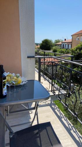 a table with a plate of fruit on a balcony at Apartmani Žužić in Poreč