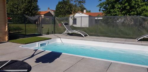 - une piscine avec une chaise dans la cour dans l'établissement Chez Marcel Gite PMR, à La Marne