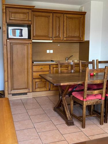 - une cuisine avec une table en bois et des placards en bois dans l'établissement Agréable appart 4Pers, Gd balcon, vue panoramique garage et wi-fi, à Orcières