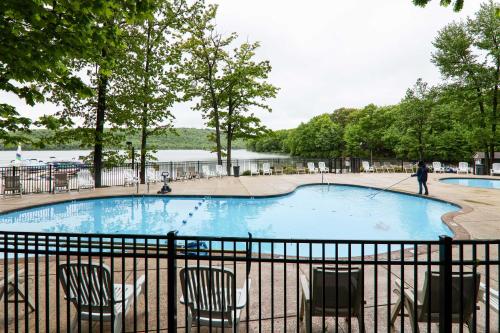 a swimming pool with chairs and a person pulling a rope at Near Skiing and Lakes Contemporary Poconos Townhome in Lake Harmony