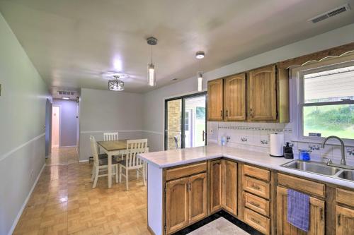 a kitchen with wooden cabinets and a dining table at Bluefield Retreat with Pool Table Near Parks! in Bluefield