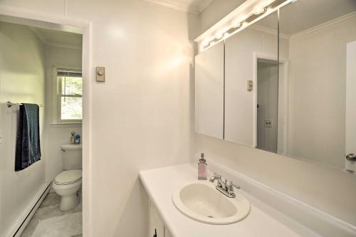 a white bathroom with a sink and a toilet at Bluefield Retreat with Pool Table Near Parks! in Bluefield