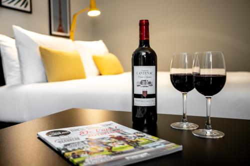 a bottle of wine and two glasses on a table at Staycity Aparthotels Bordeaux City Centre in Bordeaux