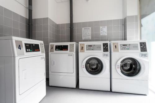 four washing machines and a washer and dryer in a room at Staycity Aparthotels Bordeaux City Centre in Bordeaux