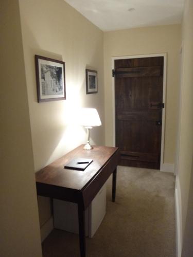 a room with a desk with a lamp and a door at Robin Hood Farm B&B in Baslow