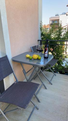 a table with a bottle of wine and fruit on it at Apartmani Žužić in Poreč