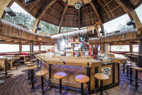 a bar in a restaurant with wooden stools at Berghotel Hochfügen in Hochfugen