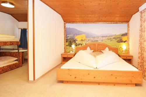 a bedroom with a bed with a painting on the wall at Hotel Chalet Olympia in Monguelfo