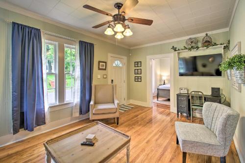 a living room with a ceiling fan and a table at half Mi to Hot Springs Natl Park Cottage with Patio in Hot Springs