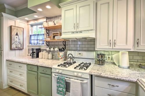 a kitchen with white cabinets and a stove top oven at half Mi to Hot Springs Natl Park Cottage with Patio in Hot Springs