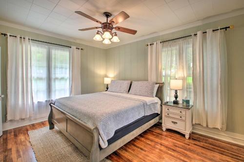 a bedroom with a bed and a ceiling fan at half Mi to Hot Springs Natl Park Cottage with Patio in Hot Springs