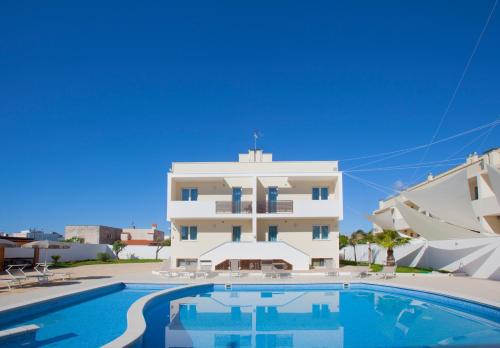 un edificio con piscina di fronte a un edificio di Casa Cardignan a Diso